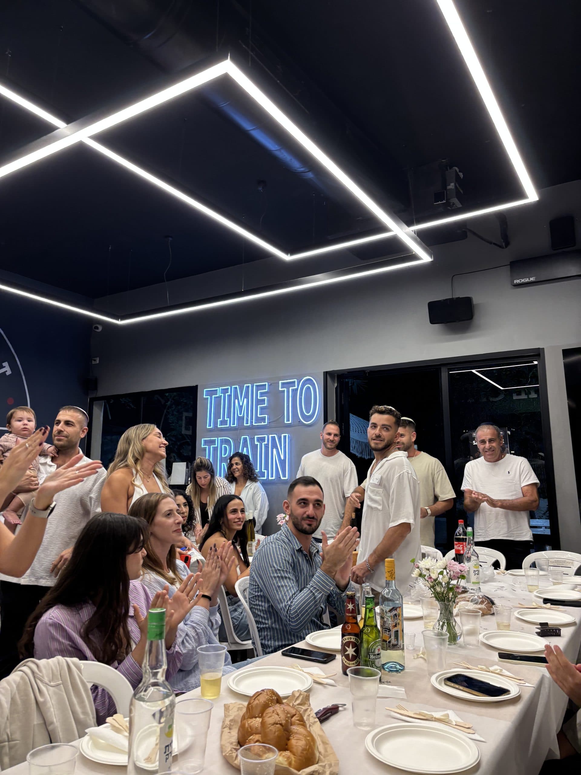 חברי הקהילה סביב שולחן שישי משותף במתחם ביננפיט